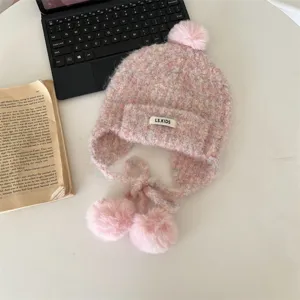 Bonnet en tricot chaud d'hiver pour enfants avec cache-oreilles et pompons, détail rose.