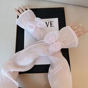 Gros plan de manchons anti-UV plissés roses en soie glacée avec élégant nœud et perle.