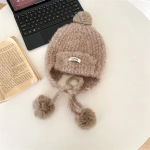 Détail bonnet tricoté chaud pour enfants, design oreillettes pelucheuses hiver avec pompons