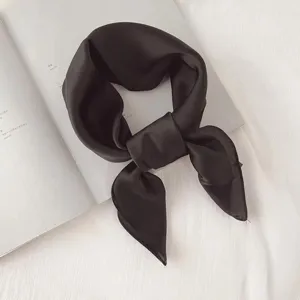 Black solid color silk square scarf detail, elegant neckerchief and hair accessory.
