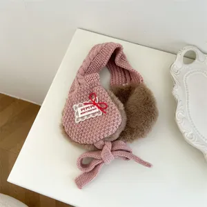 Children pink knit earmuffs with brown plush lining and cute bow for winter warmth.