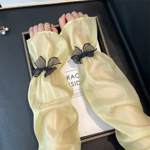 Vue détaillée de manchons jaunes transparents avec tissu léger et jolis nœuds papillon noirs.