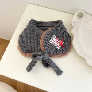 Detailed view of kids grey knit warm winter scarf collar with plush lining and cute bow tag.