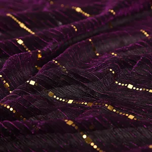 Close-up detail of luxurious purple mesh fabric featuring elegant gold sequin and dot accents.