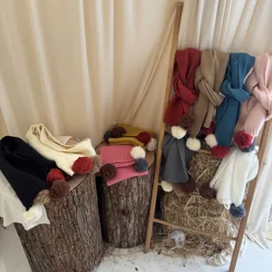 Detail d'echarpe en tricot pour enfants avec pompons colores et design chaud d'hiver.