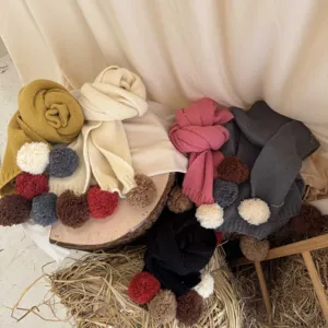 Vue détaillée d'écharpe en tricot pour enfants avec pompons colorés pour l'hiver chaud.