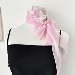 Vista dettagliata della sciarpa in chiffon rosa con delicate farfalle ricamate bianche.