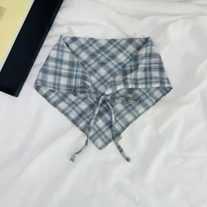 Λεπτομερές κοντινό πλάνο του καρό παιδικού τριγωνικού μαντιλιού σε μπλε και γκρι χρώμα.