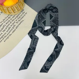 Vista dettagliata della sciarpa twilly lunga con motivo paisley nero, elegante nastro.