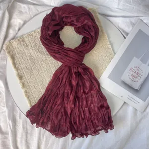 Detailed close-up of wine red pleated scarf, highlighting fabric texture and aesthetic setup.