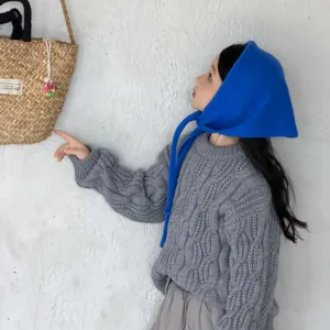 Kids blue knitted triangle scarf detail shot, cute toddler styling paired with gray sweater.
