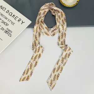 Elegant narrow silk scarf with chic leaf print, versatile twilly ribbon for neck or hair wear.