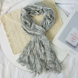 Detailed view of grey striped crinkled scarf, lightweight and breathable fabric drape.