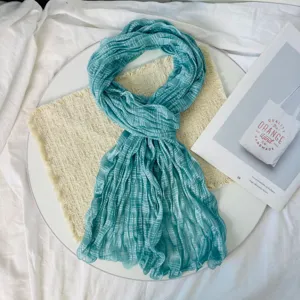 Blue pleated scarf detail, lightweight breathable summer shawl wrap texture close up view