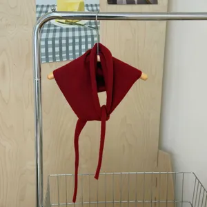 Knitted triangular scarf detail view, dark red solid color design with long straps for versatile daily styling.