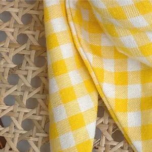 Detailed shot of yellow and white gingham cotton baby scarf showing soft texture and pattern.