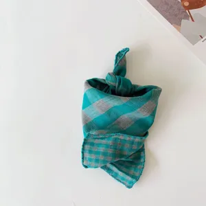 Detailed close-up of a stylish plaid baby bandana and neck scarf with knotted design.