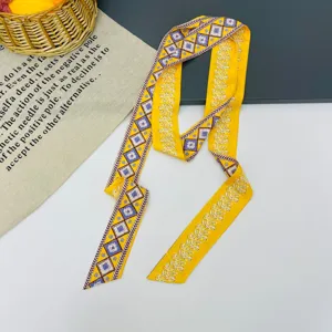 Lungo foulard twilly in seta gialla con motivo geometrico e floreale per donna elegante.