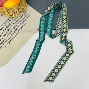 Sciarpa twilly in seta verde con eleganti motivi di viti botaniche e losanghe geometriche.