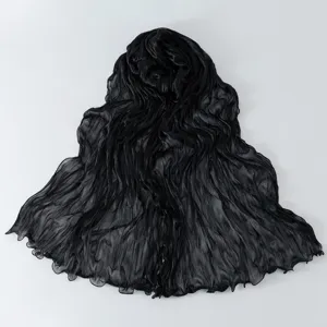 Dettaglio sciarpa trasparente stropicciata nera, tessuto leggero traspirante, bordo ondulato.