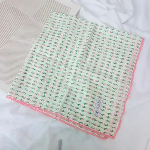 Detailed view of the cotton square scarf featuring pink floral print and lace trim.