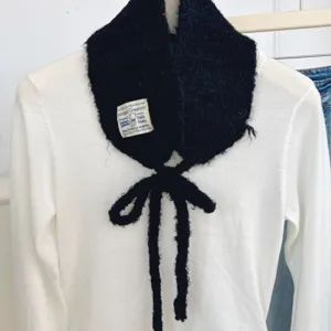 Knitted winter plush scarf bib with lovely ribbon ties, warm and stylish detail view.