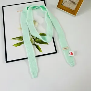 Sciarpa sottile in maglia verde chiaro, dettaglio accessorio invernale accogliente donna.