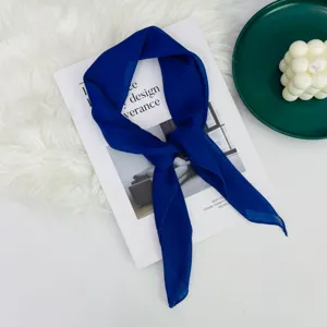 Dettaglio del foulard di seta blu reale con trama morbida e stile di legatura elegante.