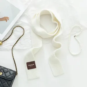 Detailansicht des weißen feinen Strick-Schals mit flachen Accessoires für Damenmode.