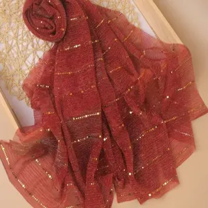 Red sequin scarf detail view, glittering metallic sparkle design for stylish autumn and winter wear.