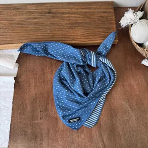 Kids double-sided dotted and striped cotton bandana scarf, detailed view on rustic wooden table.