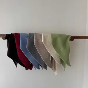 Close-up detail of multi-color wool triangular scarves neatly hanging on a wooden rod.