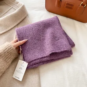 Soft purple knitted winter scarf with delicate texture and stylish attached brand hangtag detail.