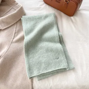 Soft green knitted scarf detail closeup, cozy texture solid color winter warm neckerchief fashion