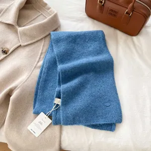 Detailed view of soft blue knitted winter scarf with cozy texture and neat flat lay style.