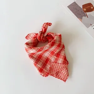 Detailed view of a soft red and white plaid baby handkerchief, cute knot design, spring accessory.