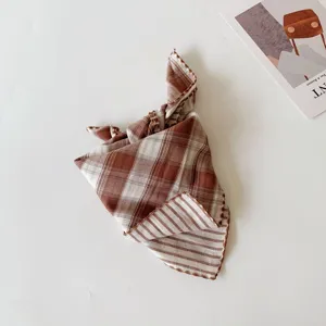 Detail view of the double-sided brown plaid and striped baby scarf, fine edge stitching.
