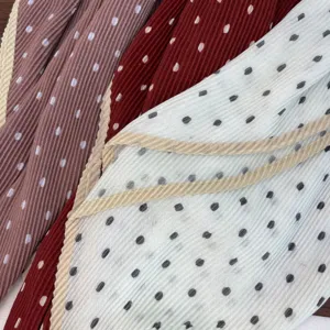 Close up of pleated polka dot scarf fabric showing fine texture and multi-color design details.