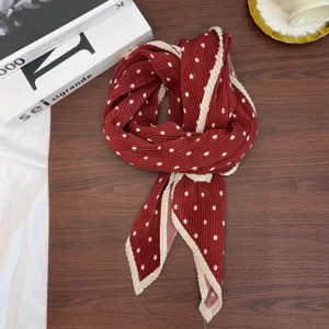 Close-up detail of a retro polka dot pleated scarf, elegant red and white neckerchief style.