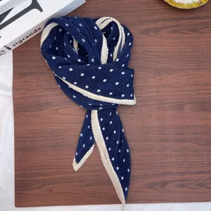 Detailed view of dark blue pleated polka dot neckerchief with stylish contrast beige edge.