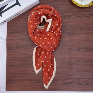 Detailed view of a vintage polka dot pleated scarf, elegant brown neckerchief accessory.