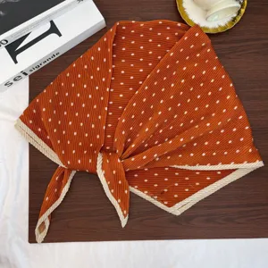 Close-up of pleated orange polka dot square scarf, vintage neckerchief detail shot.