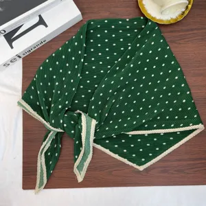Green polka dot scarf detailed view showcasing retro elegant design for autumn and winter.