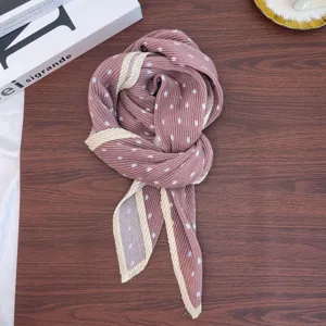 Close-up detail of the retro pleated polka dot square scarf, featuring elegant pink and cream trim.