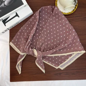 Close-up detail of retro pleated polka dot square scarf with stylish contrast border.
