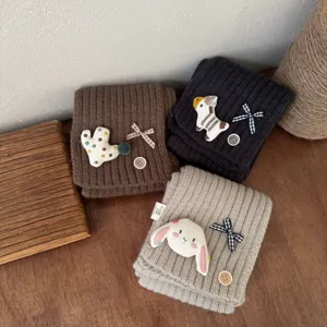 Kids winter knitted scarf detail, cute cartoon patch, soft warm material, cozy baby neck warmer.