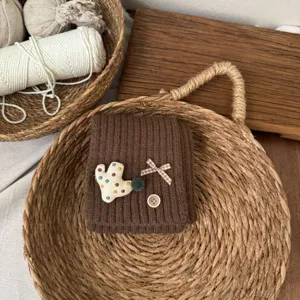 Kids brown knitted neck warmer detail, cute cactus patch and plaid bow design for winter warmth.