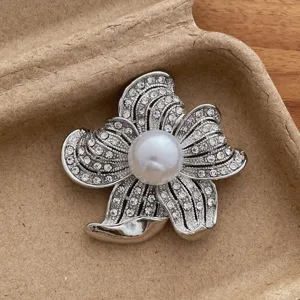 Exquisite detail of vintage rhinestone flower brooch with center pearl for elegant suit decor.