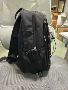 Black hiking backpack side detail showing durable fabric, mesh side pockets and secure zippers.
