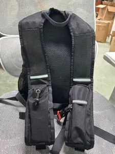 Black hiking backpack detail with breathable mesh shoulder straps and reflective safety strips.